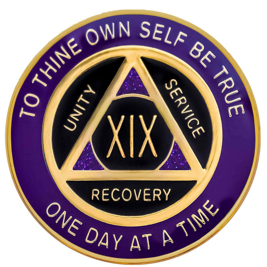 A purple and gold AA (Alcoholics Anonymous) recovery coin with text around the edge.